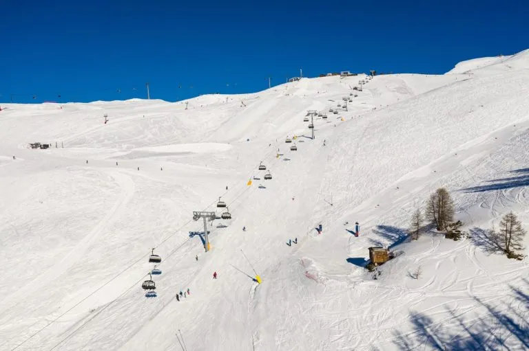 Aerial view of the Crans-montana ski resort and chair lift on a sunny winter day in the Swiss alps in Valais, Switzerland