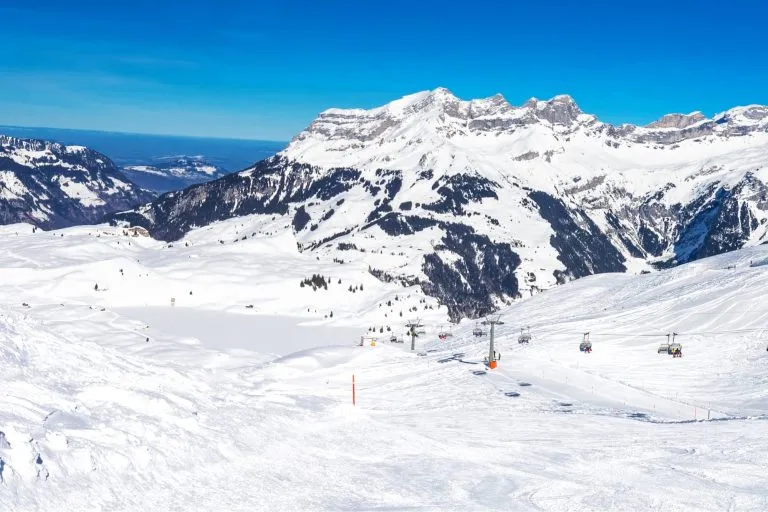 Beautiful winter landscape with Swiss Alps. Skiers skiing in famous Engelgerg - Titlis ski resort, Switzerland, Europe