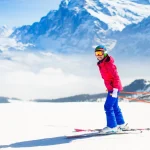 Junge Frau beim Skifahren in den Bergen.