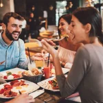 Gruppe von glücklichen Freunden beim Frühstück im Restaurant
