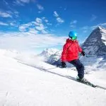 Junge attraktive kaukasische Skifahrerin auf der Skipiste im berühmten Jungfrau-Skigebiet in den Schweizer Alpen, Grindelwald, Schweiz