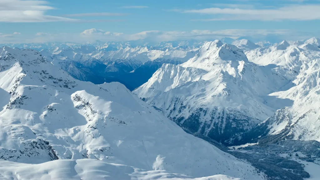 Winterliches Bergtal mit sonnigem Panoramablick vom Corvatsch-Gipfel des Unterengadins, in der Schweiz.