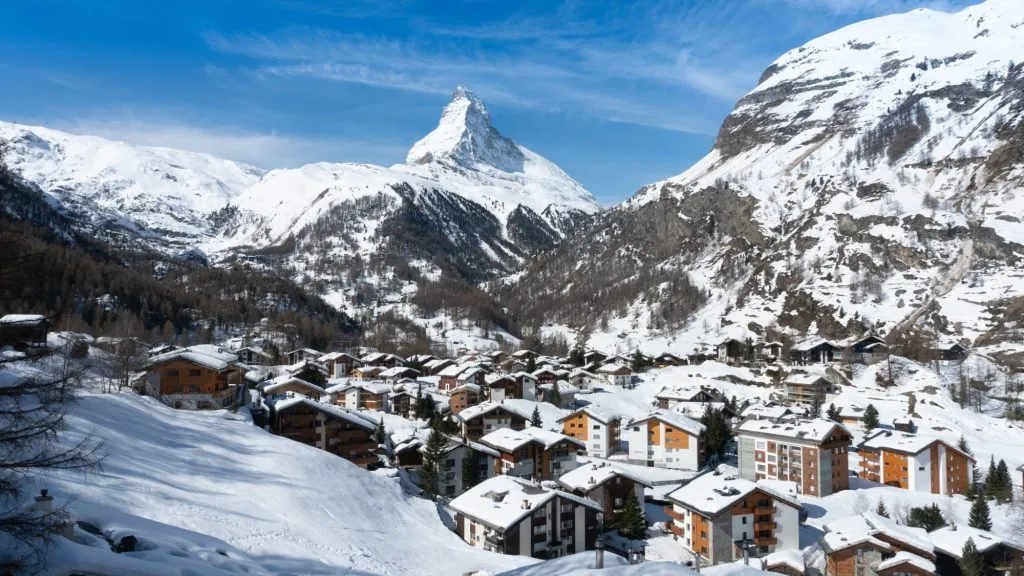 Zermatt Stadtansicht mit Matterhorn Hintergrund in einem sonnigen Tag der Wintersaison in Zermatt, Schweiz. Zermatt Dorf mit Schnee auf dem Dach. Stadtbild Blick von Gornergrat Bahn.
